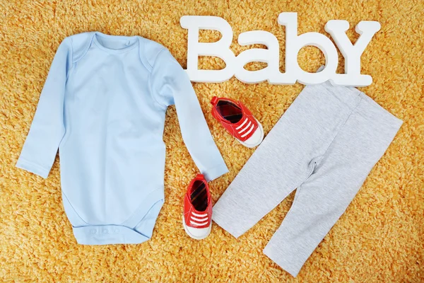Vêtements pour bébé garçon sur fond coloré — Photo