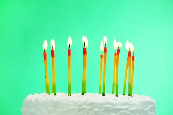 Gâteau d'anniversaire avec des bougies sur fond de couleur — Photo