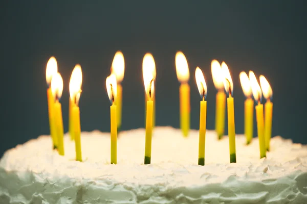 Verjaardagscake met kaarsen op donkere achtergrond — Stockfoto