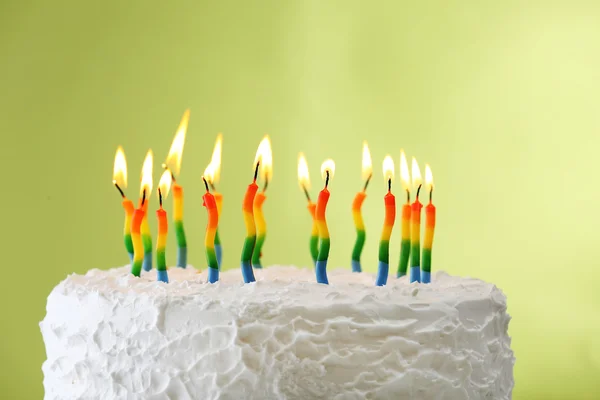Geburtstagstorte mit Kerzen auf farbigem Hintergrund — Stockbild Geburtstagstorte mit Kerzen auf farbigem Hintergrund lizenzfreie Stockbilder