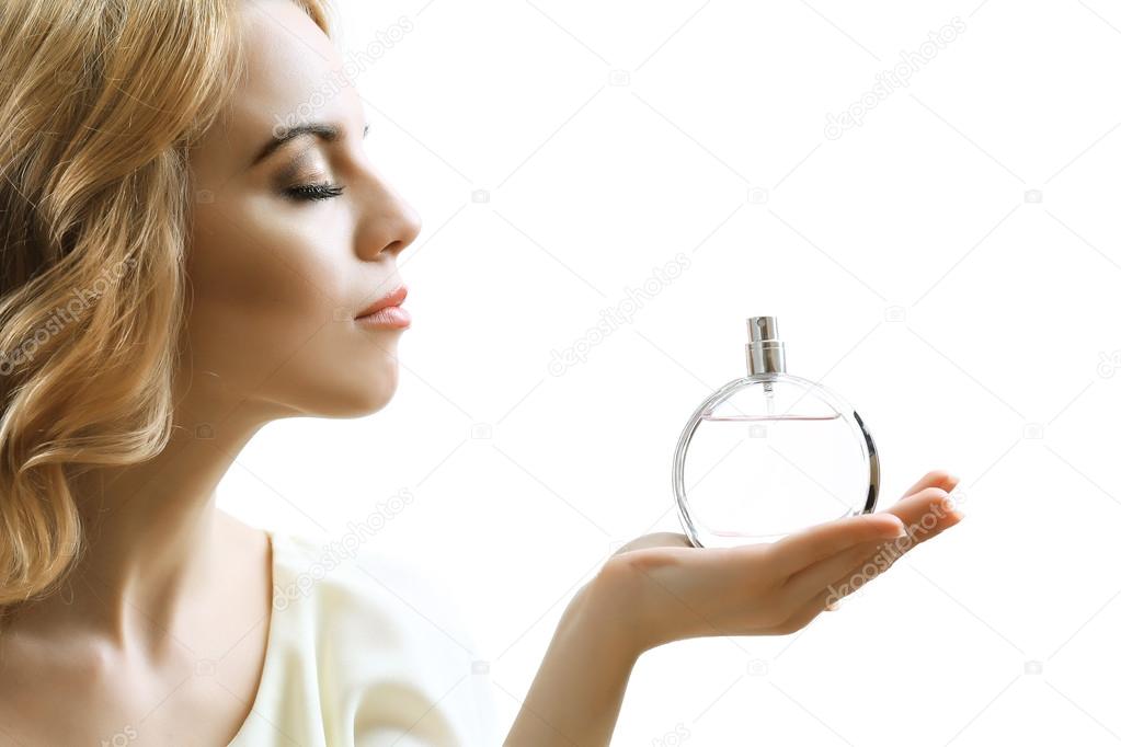 Beautiful young woman with perfume bottle isolate on white