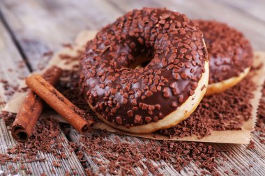 Buzlanma ile lezzetli donuts ve ahşap zemin üzerine çikolata kırıntı