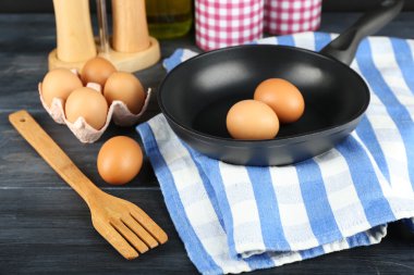 Yumurta ve ahşap arka plan üzerinde tava ile natürmort