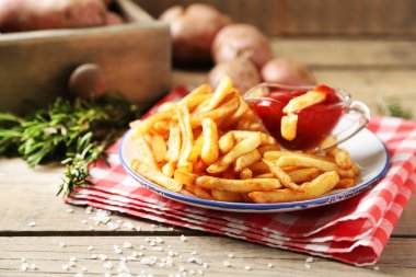 Ahşap masa arka plan üzerinde plaka üzerinde lezzetli Fransız kızartması