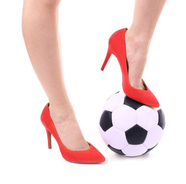 Futbol topu üzerinde beyaz izole kadın bacakları kırmızı yüksek topuklu ayakkabılarla