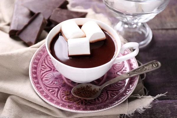 Heiße Schokolade mit Marshmallows im Becher, auf farbigem Holzgrund — Stockfoto