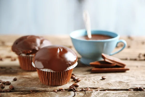 Bolos de chocolate caseiros saborosos e xícara de café na mesa de madeira, no fundo leve — Fotografia de Stock