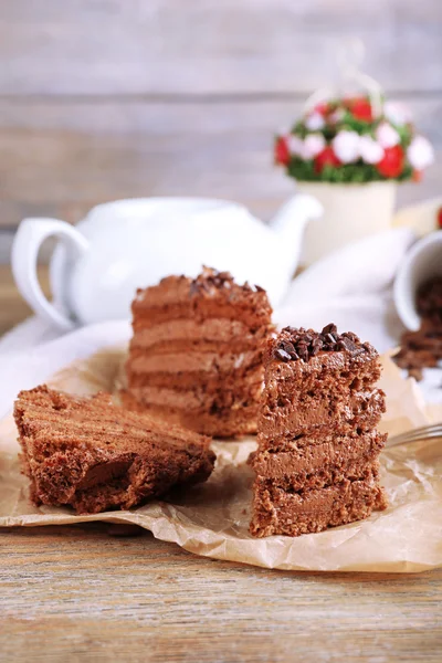 Fette di torta di cioccolato saporita su piatto su tavolo da vicino — Foto Stock
