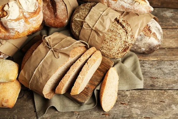 Pane fresco diverso, su vecchio tavolo di legno — Foto Stock