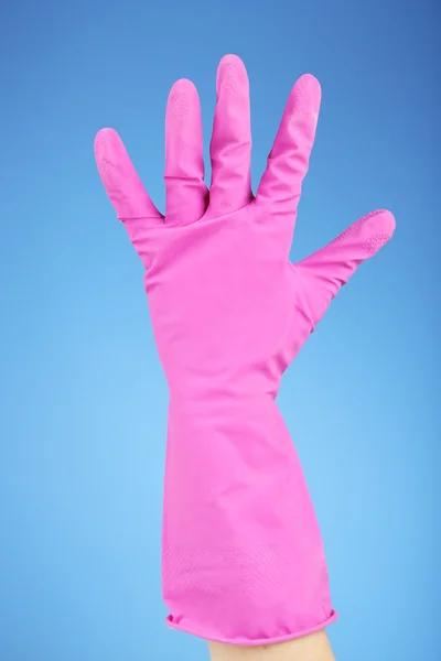 Rubber glove on hand, on blue background — Stock Photo, Image