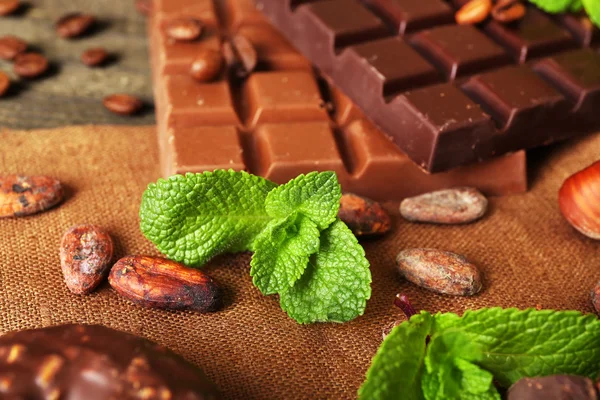 Chocolate with mint, spices and coffee beans on table, closeup — Stock Photo, Image