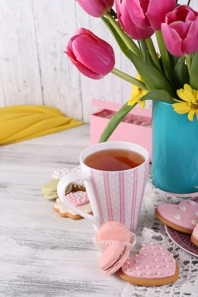 Склад весняних квітів, чаю та печива на столі крупним планом — стокове фото