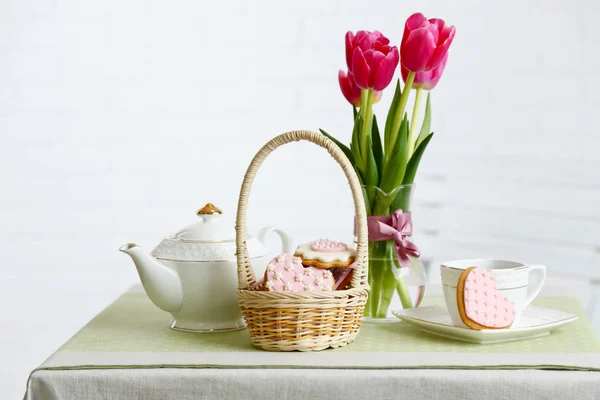 Teservis med blommor på bordet, på ljus bakgrund — Stockfoto