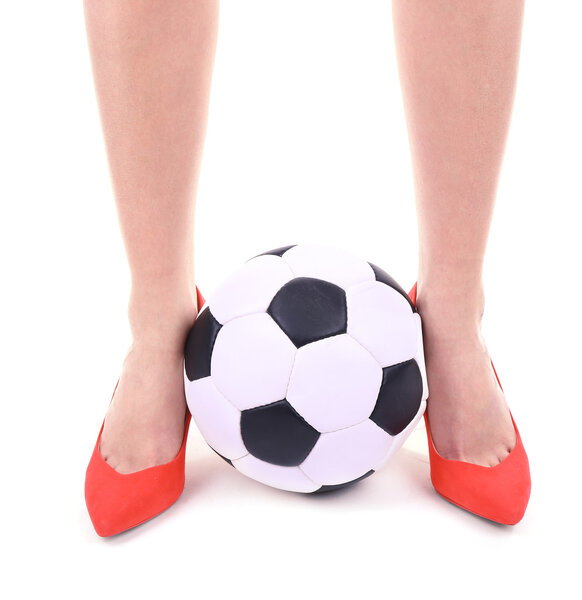 Female legs in red shoes with soccer ball isolated on white