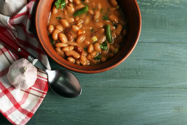 Bean soup in bowl on napkin, on wooden table background — Stock Photo, Image