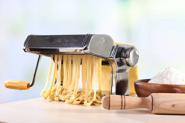 Making noodles with pasta machine on light background — Stock Photo, Image