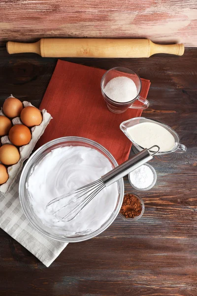 Schlageiweiß für Sahne auf Holztisch, Ansicht von oben — Stockfoto