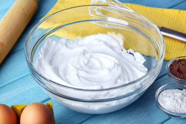 Whipped egg whites for cream on color wooden table, closeup — Stock Photo, Image