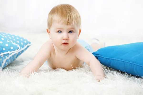 Schattige babyjongen op tapijt, op lichte achtergrond — Stockfoto