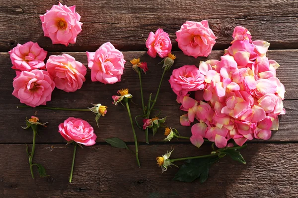 Beautiful pink roses on wooden table, top view — Stock Photo, Image