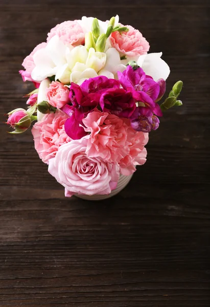 在木制的背景上的罐子里的美丽春天的花朵 — 图库照片