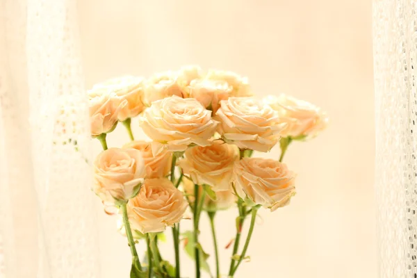 Ramo de hermosas rosas frescas en el fondo de las cortinas — Foto de Stock