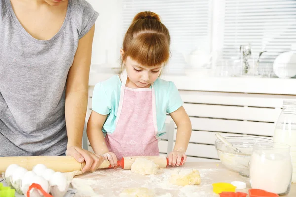 Kleines Mädchen bereitet mit Mutter zu Hause Kekse in Küche zu — Stockfoto