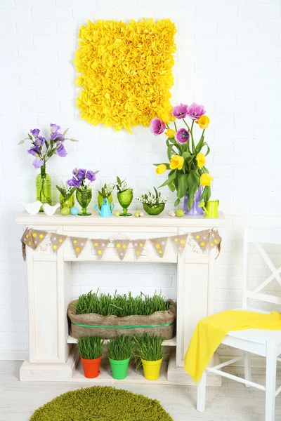 Chimenea con hermosas decoraciones de primavera en la habitación — Foto de Stock
