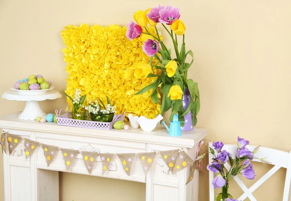 Fireplace with beautiful spring decorations in room — Stock Photo, Image