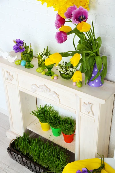 Fireplace with beautiful spring decorations in room — Stock Photo, Image