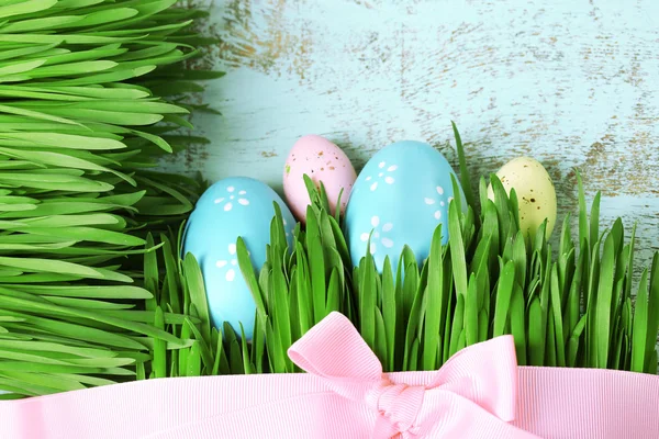 Huevos de Pascua y hierba sobre fondo de madera — Foto de Stock