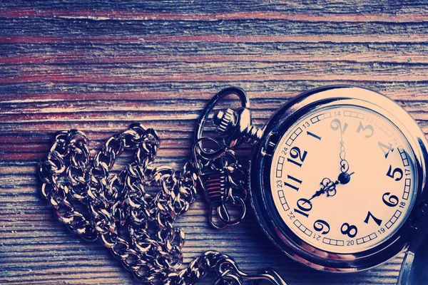 Ahşap masa üzerinde gümüş cep saati — Stok fotoğraf