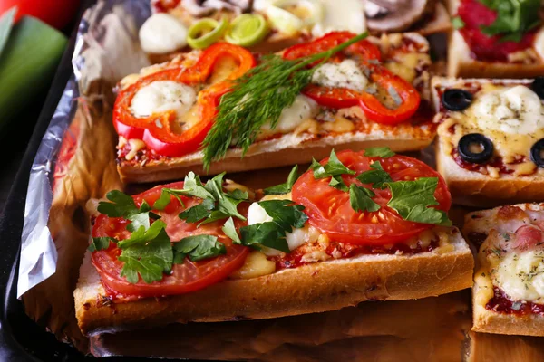 Different sandwiches with vegetables and cheese on pan close up — Stock Photo, Image