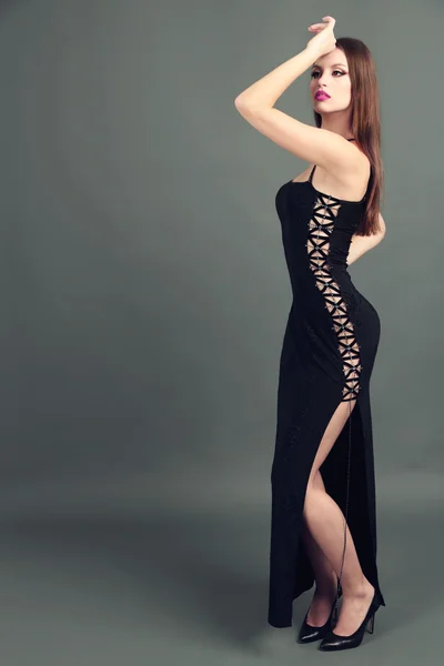 Schöne junge Frau in schwarzem Kleid auf dunkelgrauem Hintergrund — Stockfoto