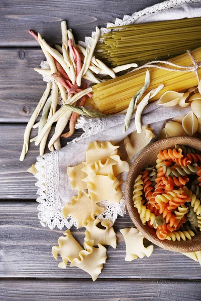 Diversi tipi di pasta su tavole di legno sfondo — Foto Stock