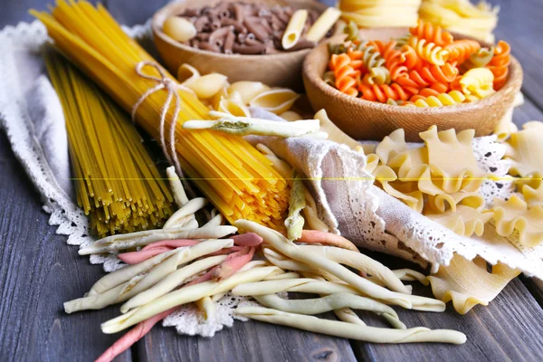 Different types of pasta on wooden planks, closeup — Stock Photo, Image