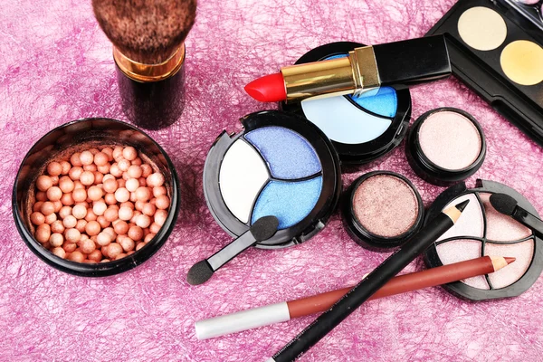 Set di cosmetici colorati su sfondo rosa testurizzato — Foto Stock