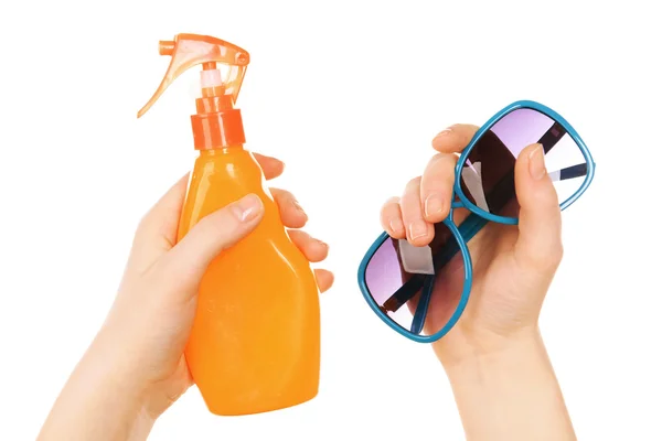 Flasche Sonnenspray und Sonnenbrille in weiblichen Händen isoliert auf weiß — Stockfoto