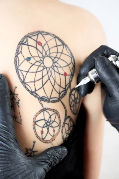 Tattooer visar processen att göra tatuering, närbild — Stockfoto