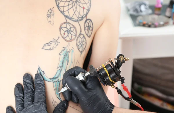 Tattooer showing process of making tattoo, close up — Stock Photo, Image