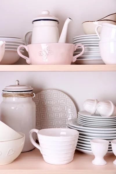 Kuchyňské potřeby a nádobí na dřevěných policích — Stock fotografie