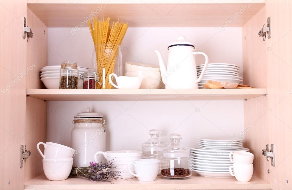 Kitchen utensils and tableware on wooden shelves