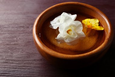 Kapta, yüzen çiçek ahşap masa arka plan üzerinde yakın çekim