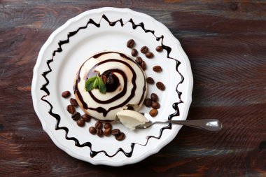 Lezzetli panna cotta tatlı plaka, ahşap masa üzerinde