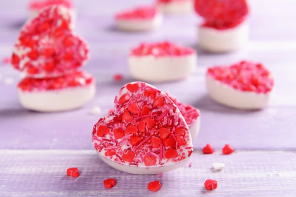 Delicious chocolate candies in heart shape on table close-up — Stock Photo, Image