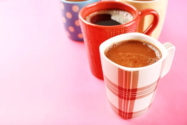 Viele Tassen Kaffee auf rosa Hintergrund — Stockfoto