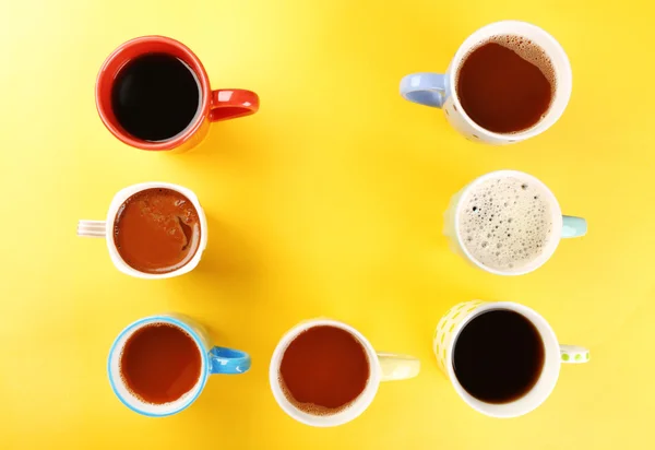 Wiele filiżanek kawy na żółtym tle — Zdjęcie stockowe