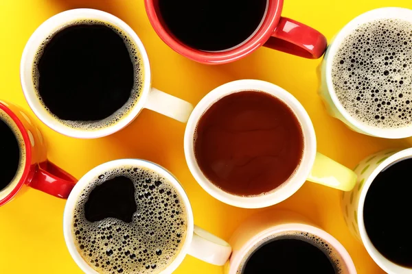 Muitas xícaras de café na tabela de cores, vista superior — Fotografia de Stock