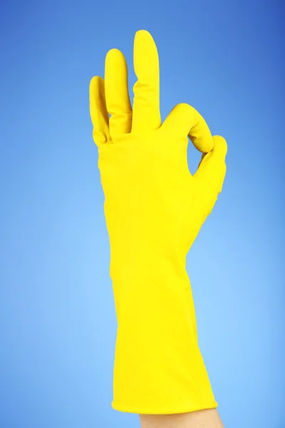 Rubber glove on hand, on blue background — Stock Photo, Image
