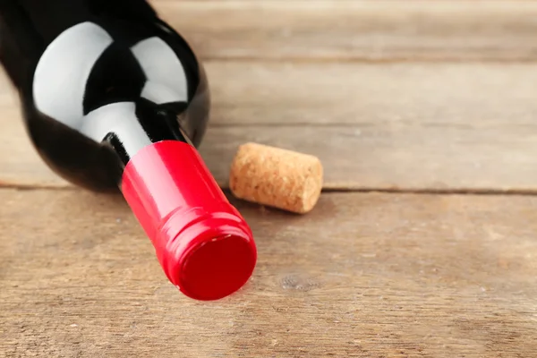 Botella de vino con corcho sobre fondo de mesa de madera —  Fotos de Stock